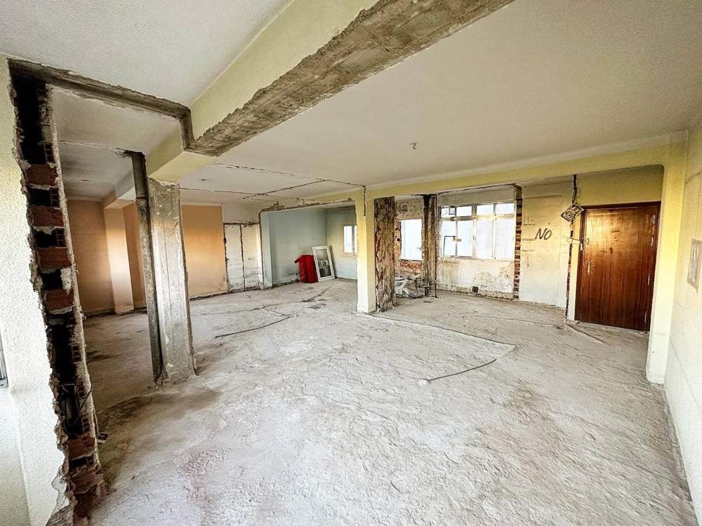 Piso con vigas y pilares a la vista después de demoler tabiques